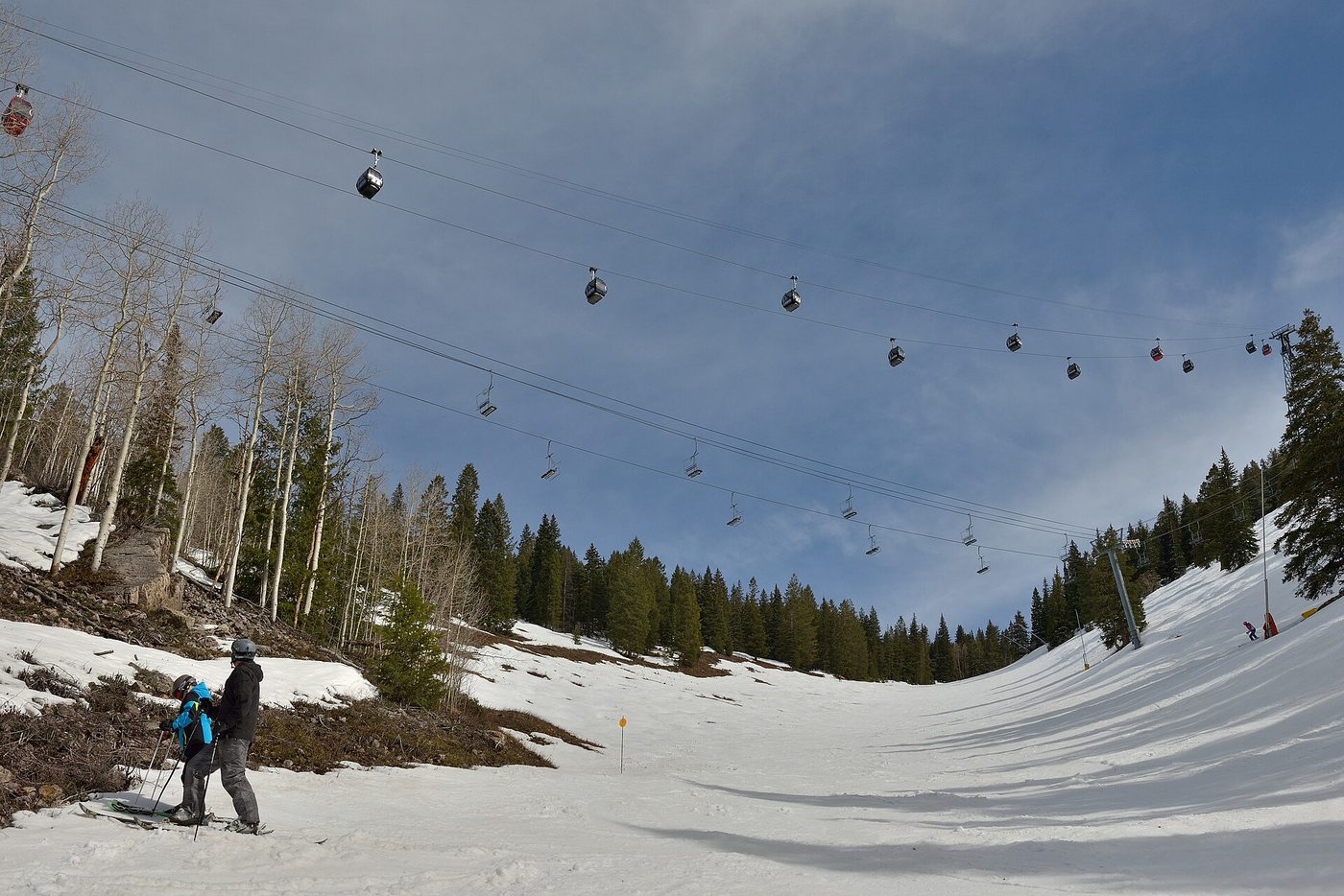 Parent and child skiing below the Aspen Mountain gondola, the household the best ski pass for families has to cover
