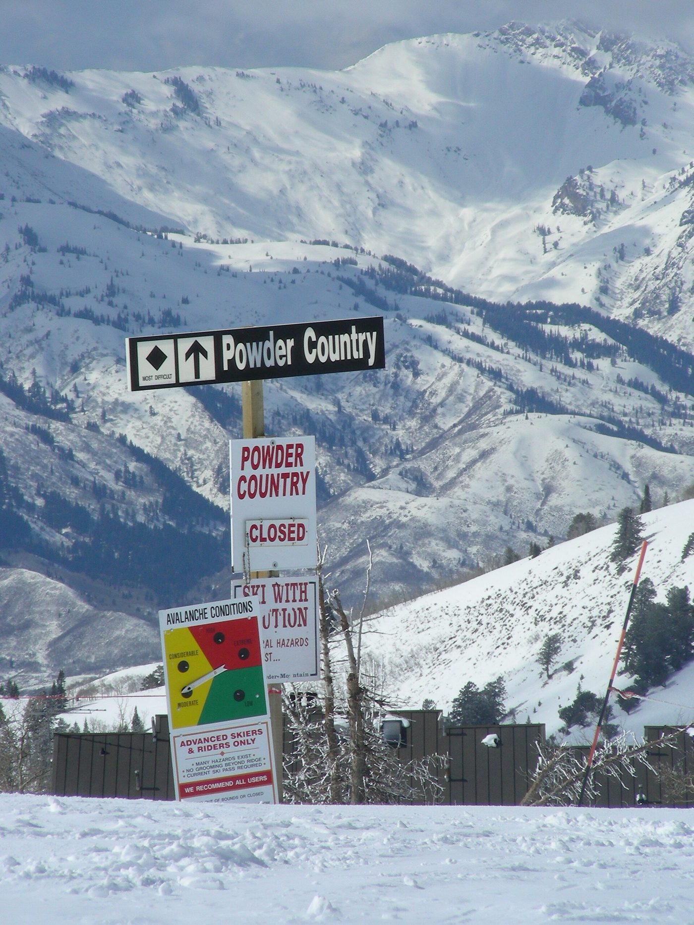 A sign marking Powder Country, advanced terrain, with an avalanche conditions board at Powder Mountain, Utah