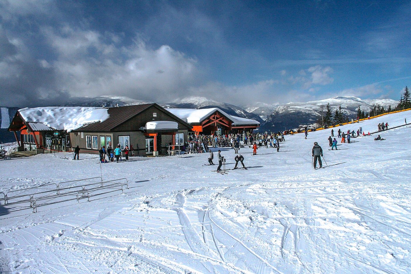 Skiers outside the mid-mountain day lodge at Revelstoke Mountain Resort, British Columbia