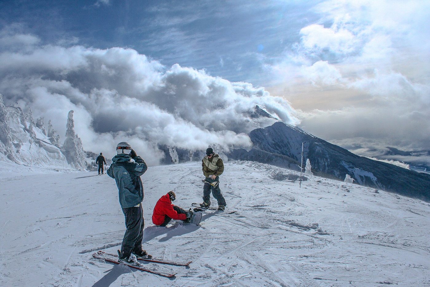 Skiers and snowboarders pausing at the top of a run above the clouds at Revelstoke, British Columbia