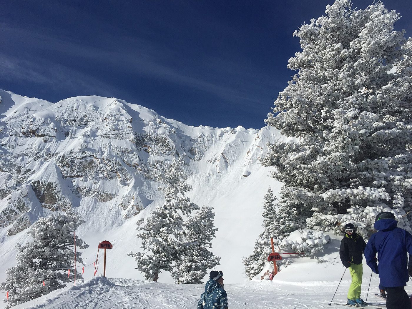 Skiers below an open bowl at Snowbasin, one of the best-regarded Utah ski resorts