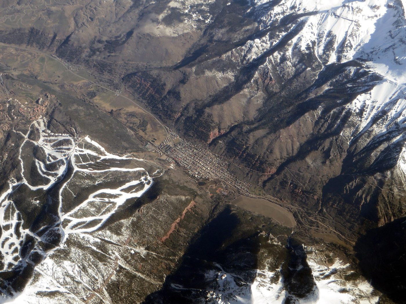 Aerial view of Telluride, Colorado, with the town on the valley floor and ski runs on the ridge above