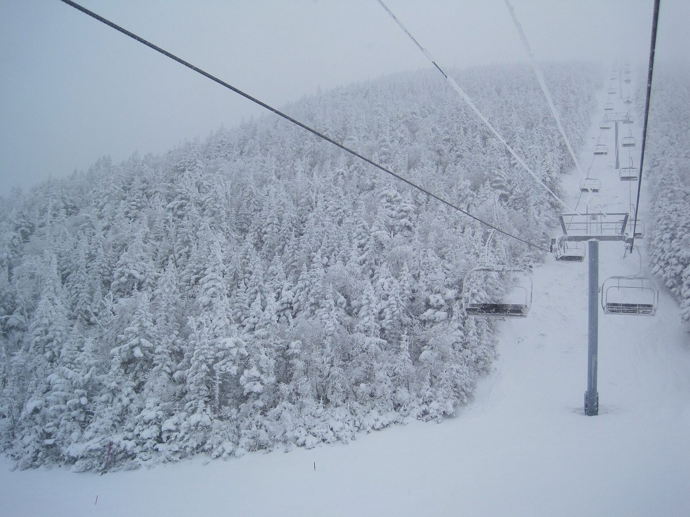 Empty chairs on the Summit Quad climbing through rime-coated spruce at Mt. Ellen, Sugarbush, Vermont, after an overnight snowfall