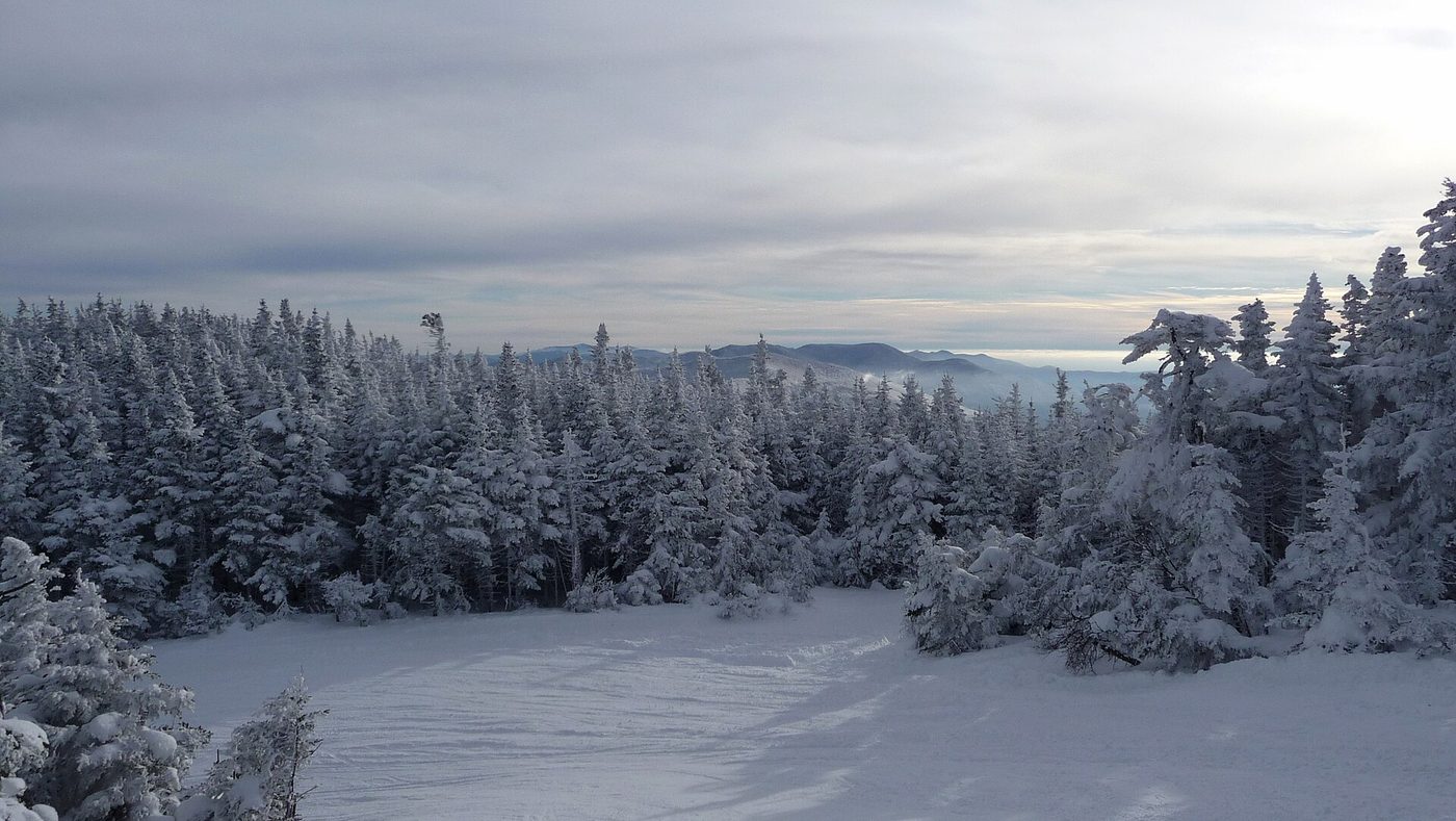 A groomed trail through rime-frosted spruce at Sugarbush, Vermont, with the Green Mountains beyond